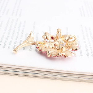 Detail view of flower brooch back showing golden safety pin clasp and hollow metalwork