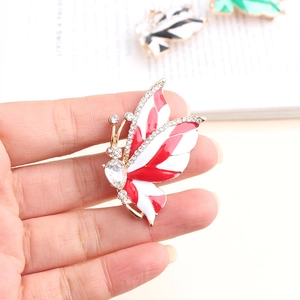 Macro detail of alloy butterfly brooch with red enamel and shimmering rhinestones