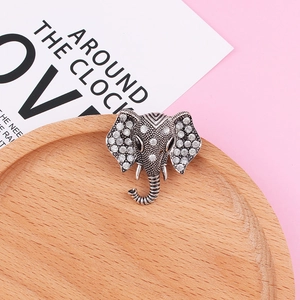 Retro silver elephant head brooch with sparkling rhinestones on a wooden tray