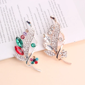 Macro shot of colorful leaf and flower brooches with rhinestones on a book