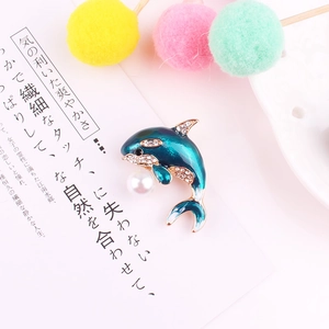 Detailed shot of dolphin brooch with blue enamel, rhinestones and white pearl