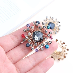 Detailed macro of a gold sunflower brooch with colorful crystals and grey center stone