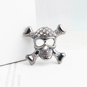Détail macro d'une broche tête de mort gothique avec strass brillants en métal foncé