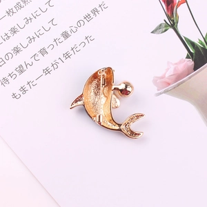 Golden dolphin brooch with enamel and crystals featuring a classic pin back clasp