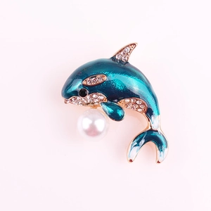 Detail of blue enamel dolphin brooch with sparkling crystals and a white pearl drop
