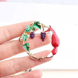 Enamel brooch with cute red fox, purple grapes and green leaves in a circular wreath design