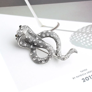 Gros plan détaillé d'une broche serpent cobra argentée avec strass brillants et yeux en pierres noires