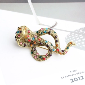 Détail d'une broche serpent en or antique ornée de cristaux multicolores et de strass fins