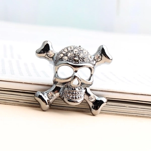 Broche tête de mort vintage en métal noir avec strass brillants et os croisés
