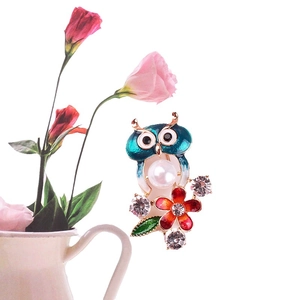 Emaillierte Eule-Brosche mit Perle und Strass an einem weißen Blumentopf gelehnt
