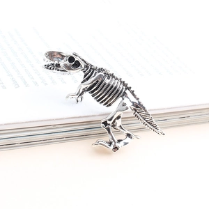 Détail macro d'une broche squelette de dinosaure en argent vintage gravé avec soin