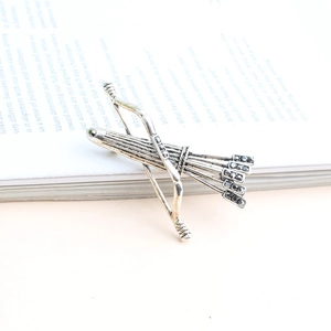Vue détaillée d'une broche flèche vintage en argent sertie de cristaux sur un livre