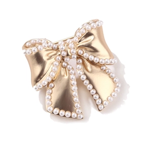 Elegant gold bow brooch with white pearls, minimalist matte finish on white background