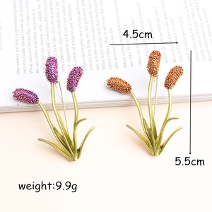 Detail of lavender flower brooch with purple and bronze enamel beads on light background