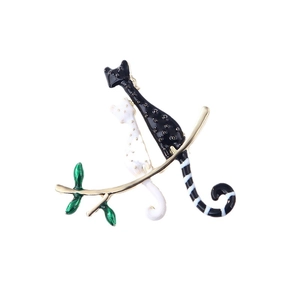 Broche double chat en émail avec pois noirs et blancs sur une branche dorée