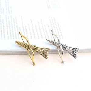Broches flèches dorées et argentées avec strass sur la page d'un livre blanc