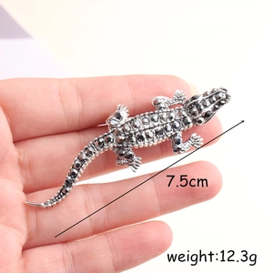 Détail d'une broche crocodile de 7,5cm avec strass noirs sur base en métal argenté