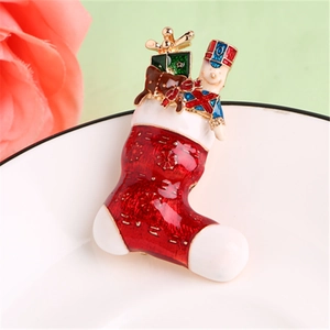 Broche émaillée en forme de chaussette de Noël avec casse-noisette sur plateau blanc