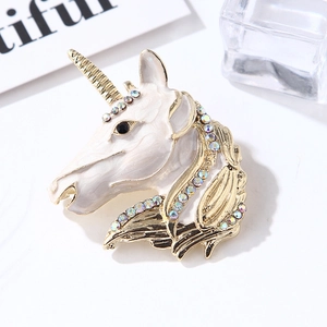 Macro view of unicorn brooch with white enamel, colorful rhinestones and gold plating