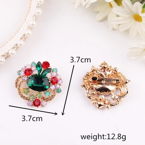 Elegant floral rhinestone brooch with green center stone and gold-plated safety pin