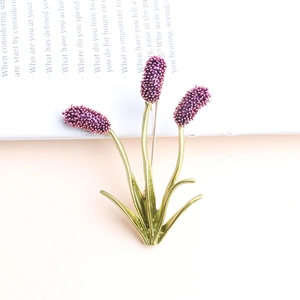 Chic purple enamel flower pin brooch with lavender design on an open book background