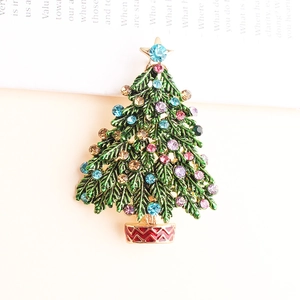 Makro-Detail einer Weihnachtsbaum-Brosche mit grüner Emaille und bunten Strasssteinen