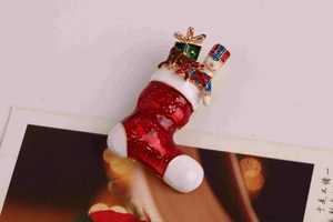 Détail de la broche chaussette de Noël avec bonhomme de neige sur fond de carte festive