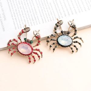 Broche crabe vintage avec strass et pierres d'opale sur un livre ancien