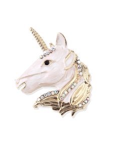 Close-up of unicorn enamel brooch with gold alloy frame and sparkling rhinestones