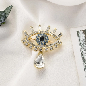 Détail de la broche œil avec strass bleus et pendentif en cristal en forme de larme