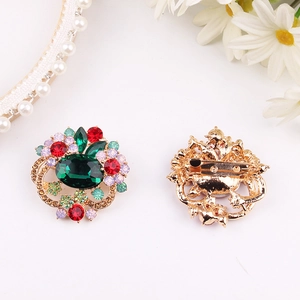 Vintage floral brooch with emerald and ruby crystals on gold base, front and back view