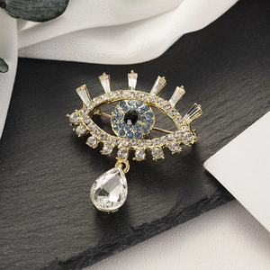 Détail de la broche œil avec zircons bleus et pendentif transparent en forme de goutte