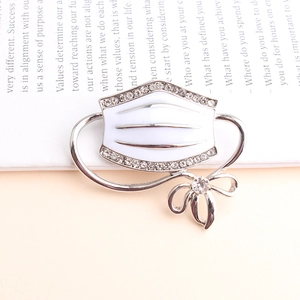 Creative white mask enamel brooch with rhinestones on an English magazine background