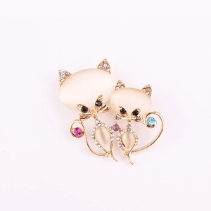 Détail d'une broche chat avec des strass brillants et des pierres œil de chat jaunes
