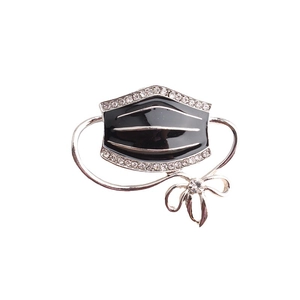 Creative black enamel face mask brooch with sparkling rhinestones and silver bow detail