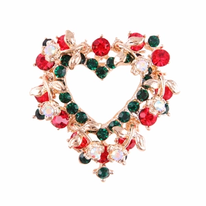Detalle del broche de corazón navideño con cristales rojos y verdes en metal dorado
