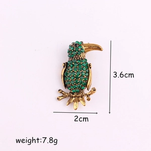 Macro shot of green rhinestone parrot brooch showing 3.6cm x 2cm size and 7.8g weight