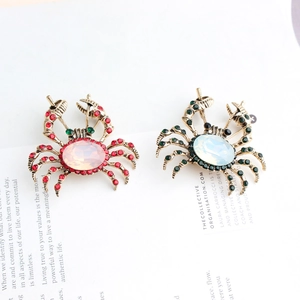 Détail de broches crabe vintage avec strass colorés et pierres opalescentes