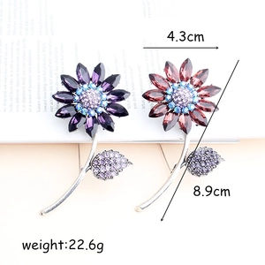 Sunflower brooch pins with crystal petals and diamond accents in purple and red hues