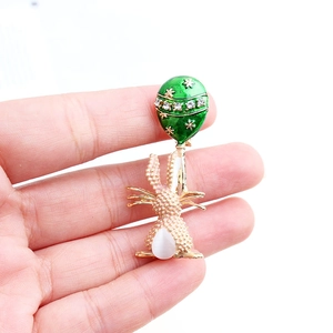 Dettaglio della spilla a coniglio con smalto verde, fiori bianchi e piccoli strass