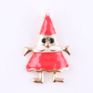 Detalle del broche navideño en esmalte rojo con acabado dorado y pedrería en color verde
