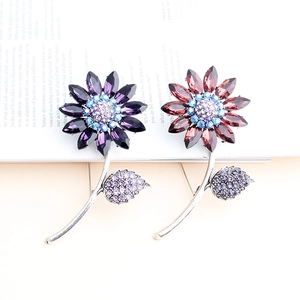 Detailed macro view of crystal sunflower brooches in purple and burgundy vintage style