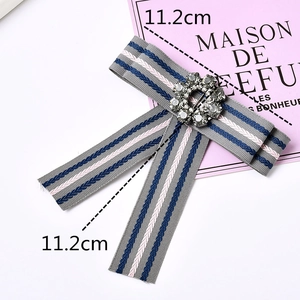 Elegant grey ribbon bow brooch with pink blue stripes and central sparkling crystal
