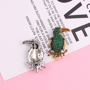 Exquisite golden toucan bird brooch with green rhinestones shown in front and back views