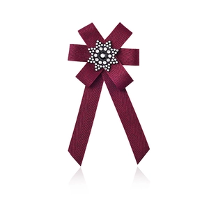 Detailed view of the layered wine red striped fabric bow brooch with a sparkling star center