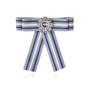Detailed view of striped bow brooch featuring a sparkling crystal center and fabric texture
