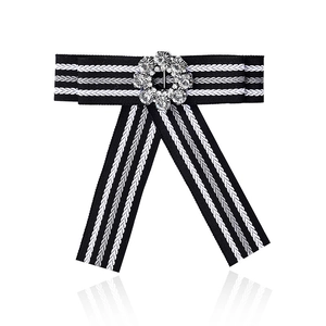 Detail of black and white striped bow brooch with a sparkling round rhinestone flower center