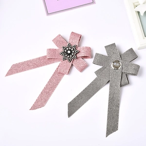 Detail of pink and gray ribbon bow brooches with rhinestone snowflake and safety pin