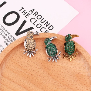 Detailed view of animal bird brooches with sparkling crystals in vintage alloy design
