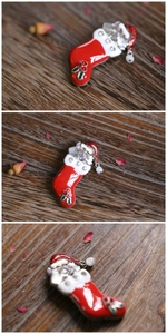 Macro detail of Christmas cat in stocking brooch with rhinestones and pearl drop